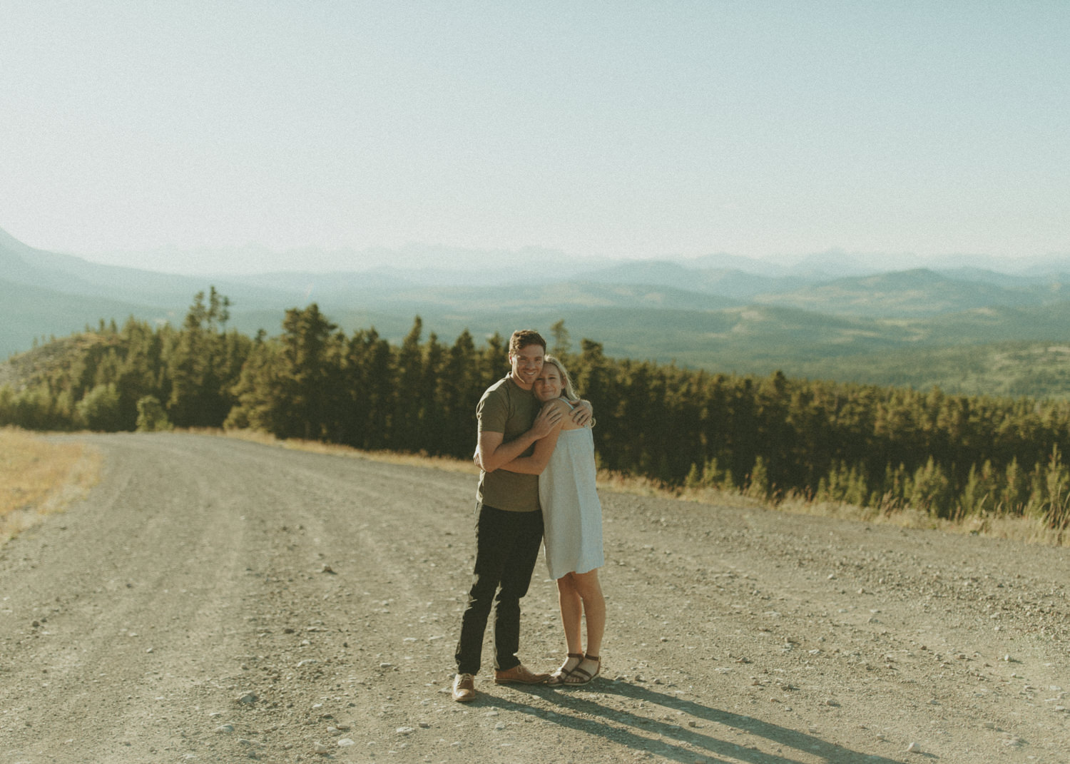Couple hugging on a dirt road in the mountains